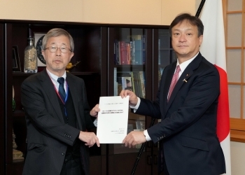 政策研究大学院大学の飯村座長から提言書を受け取る堀井外務副大臣
