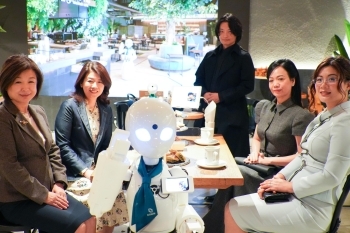 ロボットを囲んで懇談する両夫人と従業員