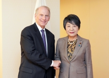 ハース名誉会長と握手しながら記念撮影をする上川外務大臣