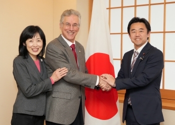 正面を向き、笑顔で握手を交わす、穂坂政務官とオボン・ソサエティ共同代表の様子