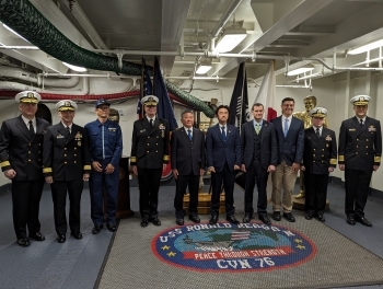 米空母ロナルド・レーガン艦内において、写真撮影に応じる、穂坂政務官と関係者の様子