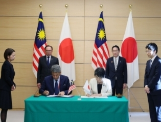 OSA文書に署名をしている日・マレーシアの両外相