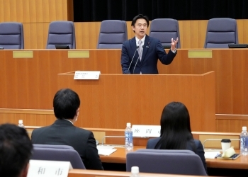 演台に立ち、スピーチする、穂坂政務官の様子(接写)