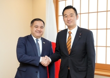 正面を向き、握手を交わす、深澤政務官とアブドゥラフモノフ大使の様子