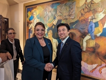 カストロ大統領と握手しながら記念撮影をする穂坂政務官