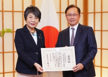 佐藤特別顧問と賞状を掲げる上川外務大臣