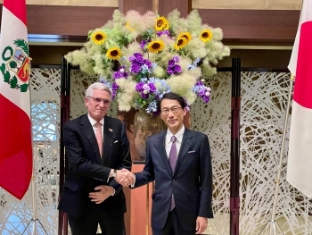 カミノ外務副大臣と握手する小野外務審議官の記念写真