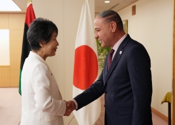 目線を合わせて握手する日・リビア両外相