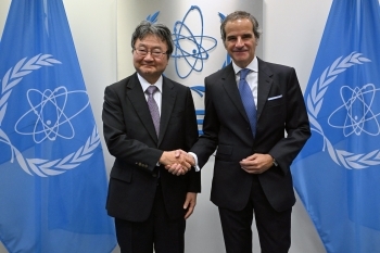 グロッシーIAEA事務局長と握手をする上坂充内閣府原子力委員会委員長