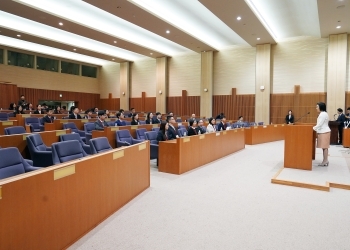 壇上で挨拶する生稲外務大臣政務官と参加者一行