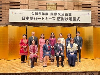 壇上で他の参加者とともに写真撮影に応じる生稲外務大臣政務官
