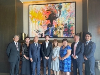 日本企業等関係者と絵画の前で写真撮影する英利政務官