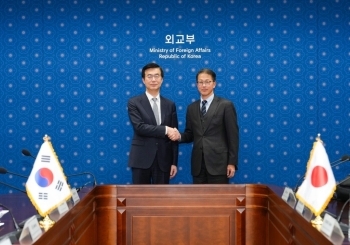 こちらを向いて握手をする北村俊博外務報道官とイ・ジェウン韓国外交部報道官