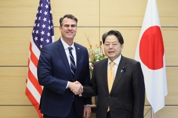 握手する林官房長官とスティット・オクラホマ州知事