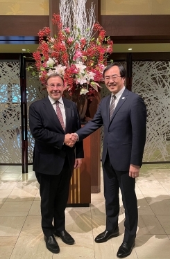 シュタイナーUNDP総裁と握手をする赤堀外務審議官