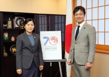 国際協力70周年記念パネルを挟んでの宮路外務副大臣とポーンワン・ラオス計画投資副大臣の記念写真