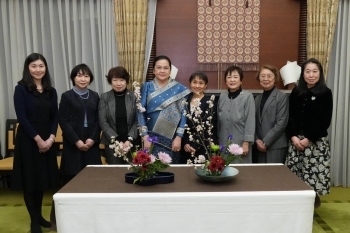 生け花を前にいけばなインターナショナル東京支部講師たちとともに写真撮影に応じる石破佳子総理大臣夫人とワンダラー・シーパンドン・ラオス人民民主共和国首相夫人