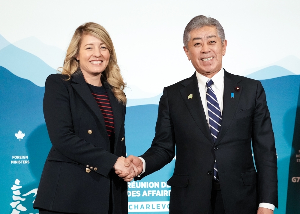 握手して写真撮影に応じる岩屋外務大臣とカナダのメラニー・ジョリー外務大臣
