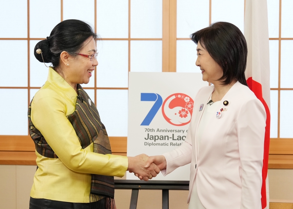 お互いを見つめながら握手をする生稲外務大臣政務官とフォンサムット・アンラワン駐日ラオス大使