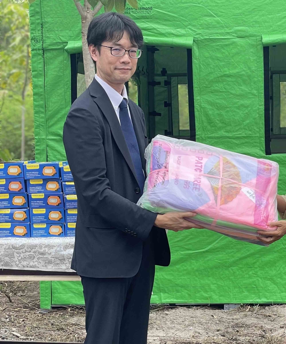 緊急支援セットを学校に引き渡す日本大使館スタッフ