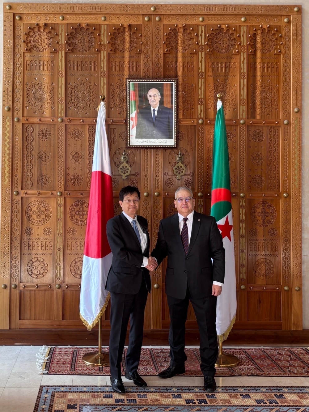 外務次官と握手する松本外務政務官の姿