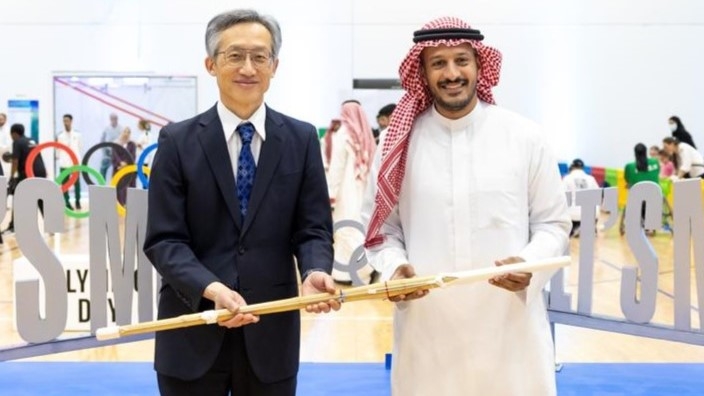 大使と事務総長が剣道の竹刀を手に持っている様子