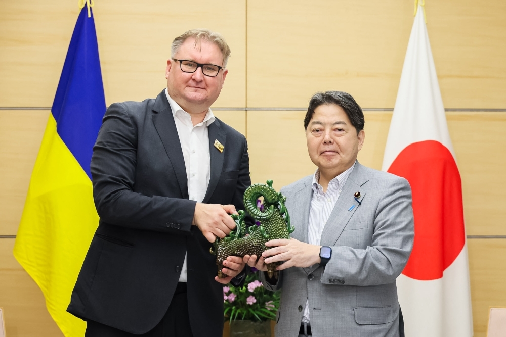 ウクライナからの贈呈品を手にする林官房長官とカチカ副首相