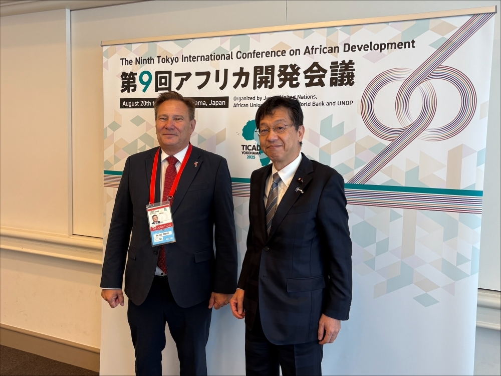 フィリップ・デュヌトン・ユニットエイド事務局長と写真撮影する松本政務官