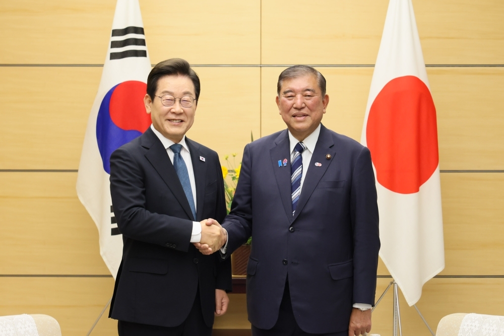握手して写真撮影に応じる石破総理大臣と李在明(イ・ジェミョン)大統領