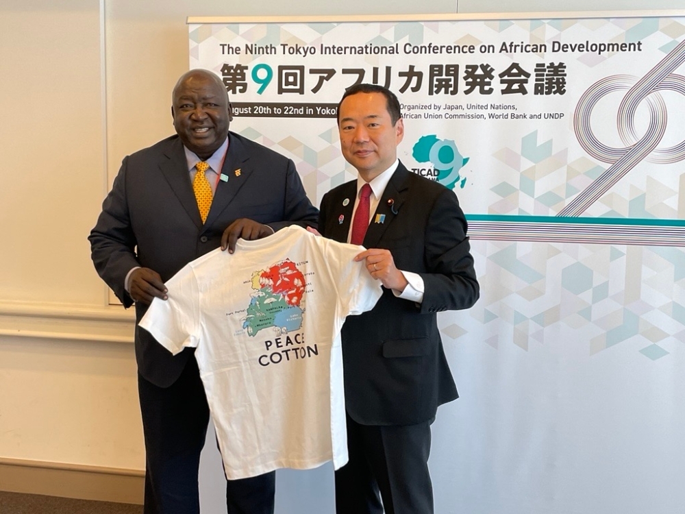 Tシャツを披露するオケロ国務大臣と藤井副大臣