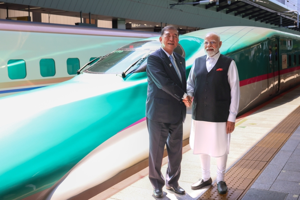 新幹線の前で握手をする石破総理大臣とモディ・インド首相