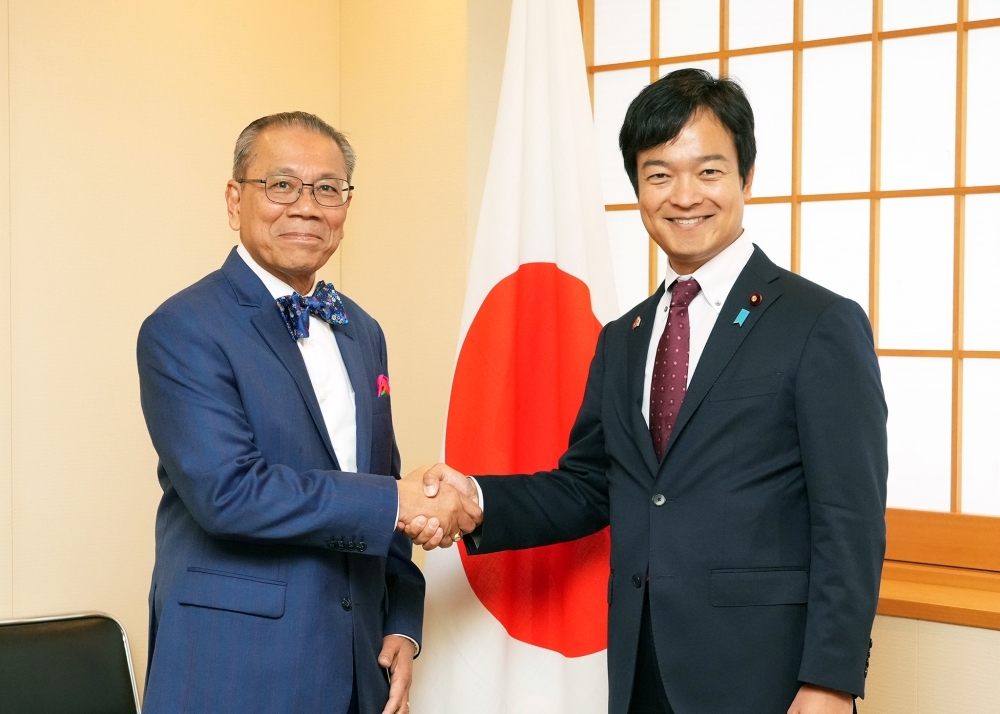 握手をする宮路外務副大臣とソック・シパナ・カンボジア上級大臣