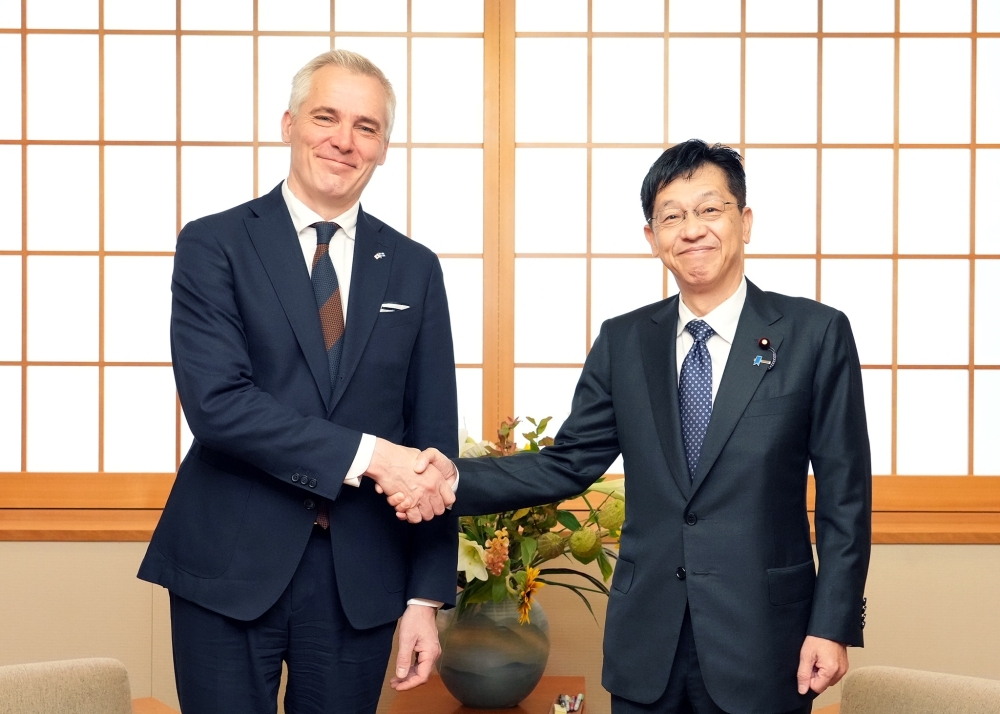 笑顔で握手する松本政務官とアドラークロイツ大臣