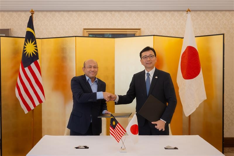OSA案件に関する書簡の署名・交換後に握手をする四方駐マレーシア大使とモフド・ヤニ・ビン・ダウド・マレーシア国防省副次官