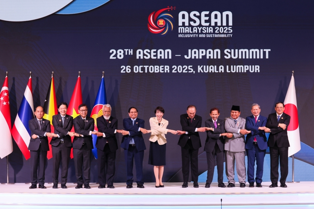 手を取り合って写真撮影する日・ASEAN首脳会議出席者