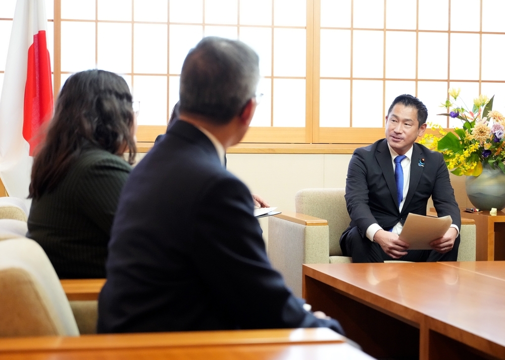 プログラム参加者一行と懇談する大西政務官