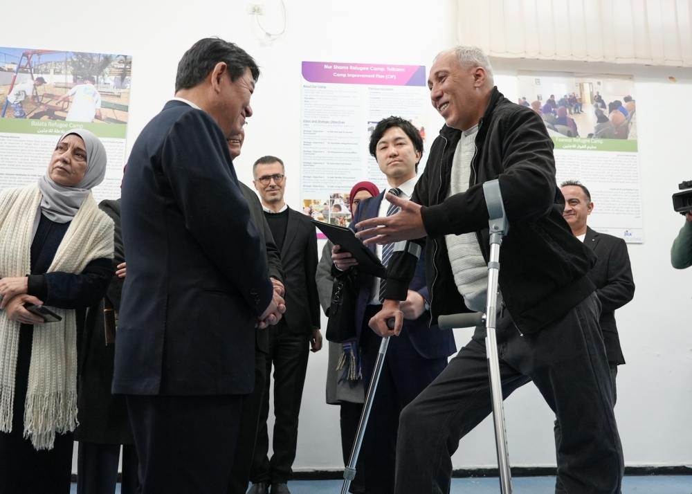 杖をついている難民男性と懇談をする茂木外務大臣