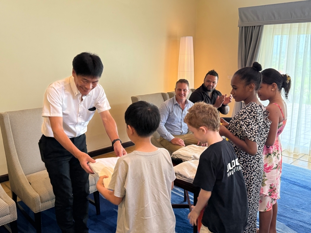 柔道着をこどもたちに手渡しする島田外務大臣政務官の様子