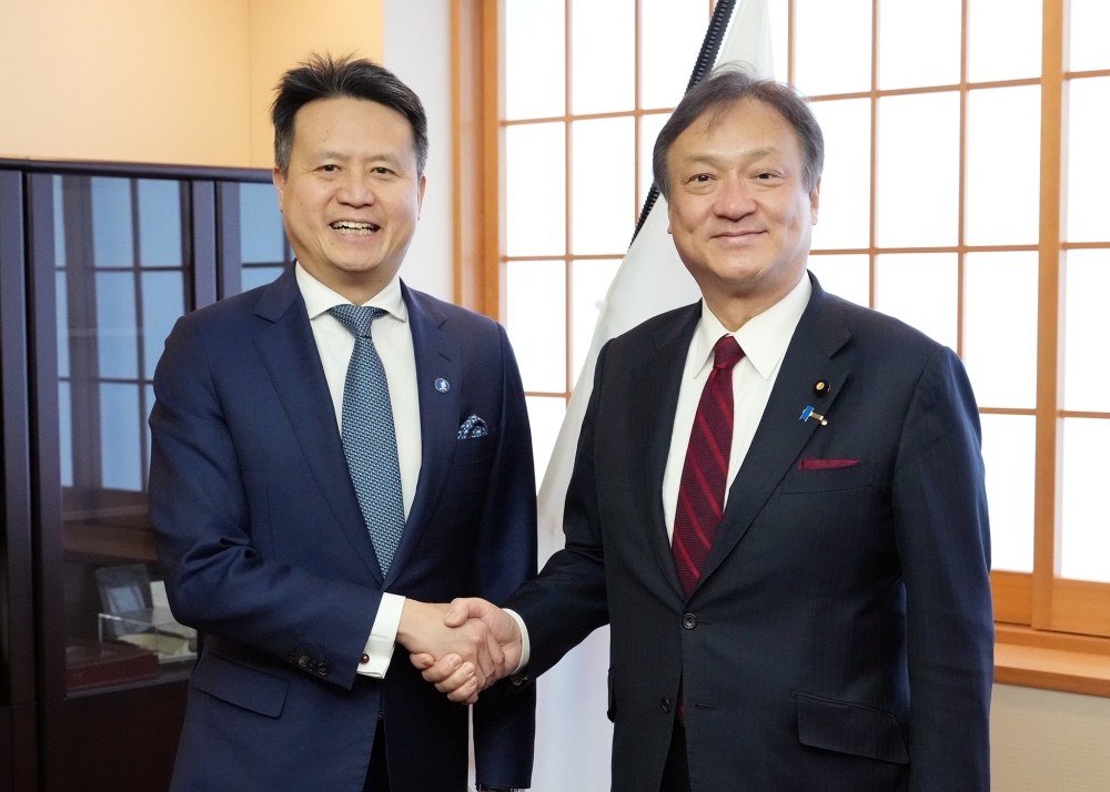 握手をする堀井副大臣とタン事務局長