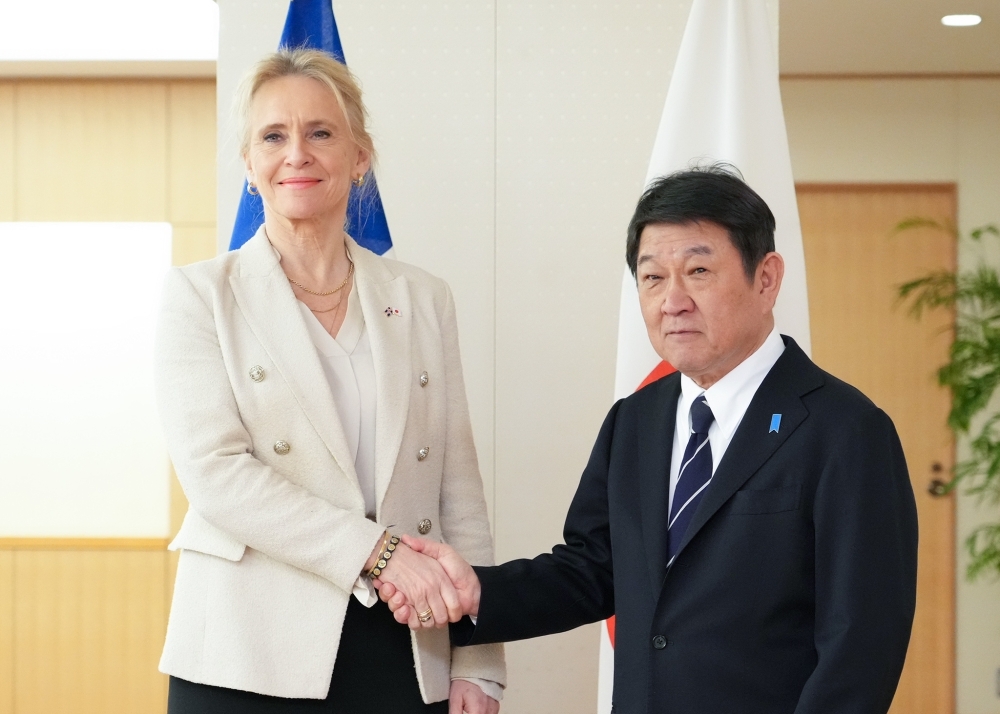 握手をした状態で撮影に応じる茂木大臣とグンナルスドッティル外相