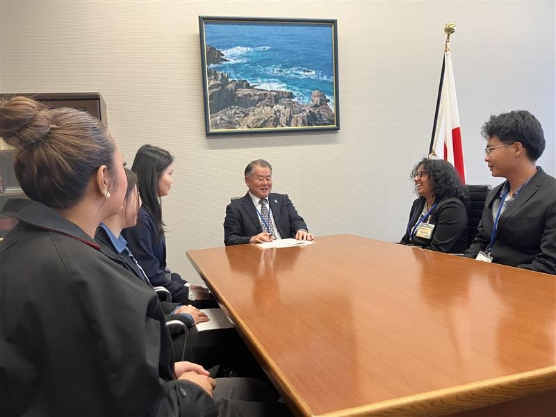 アジア系米国人青少年招へい一行のメンバーからの表敬を受ける尾上補佐官の様子