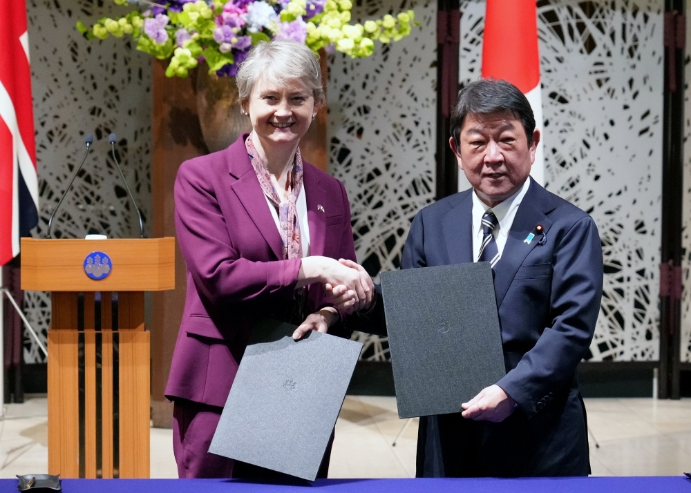 署名を交換し握手をする茂木大臣とクーパー外相