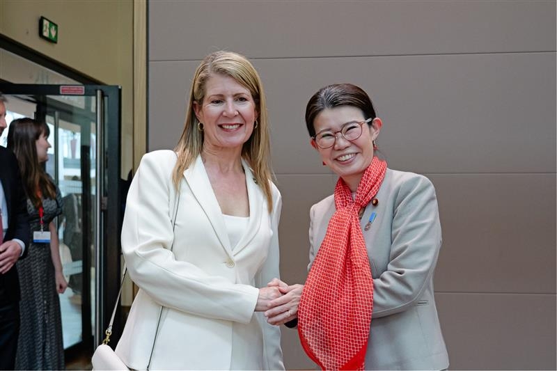 握手をする国光外務副大臣とジェニー・チャップマン女男爵・英外務・英連邦・開発省閣外大臣