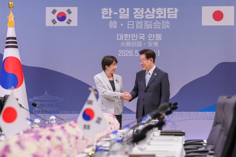 李在明大統領と会談前に握手する高市総理