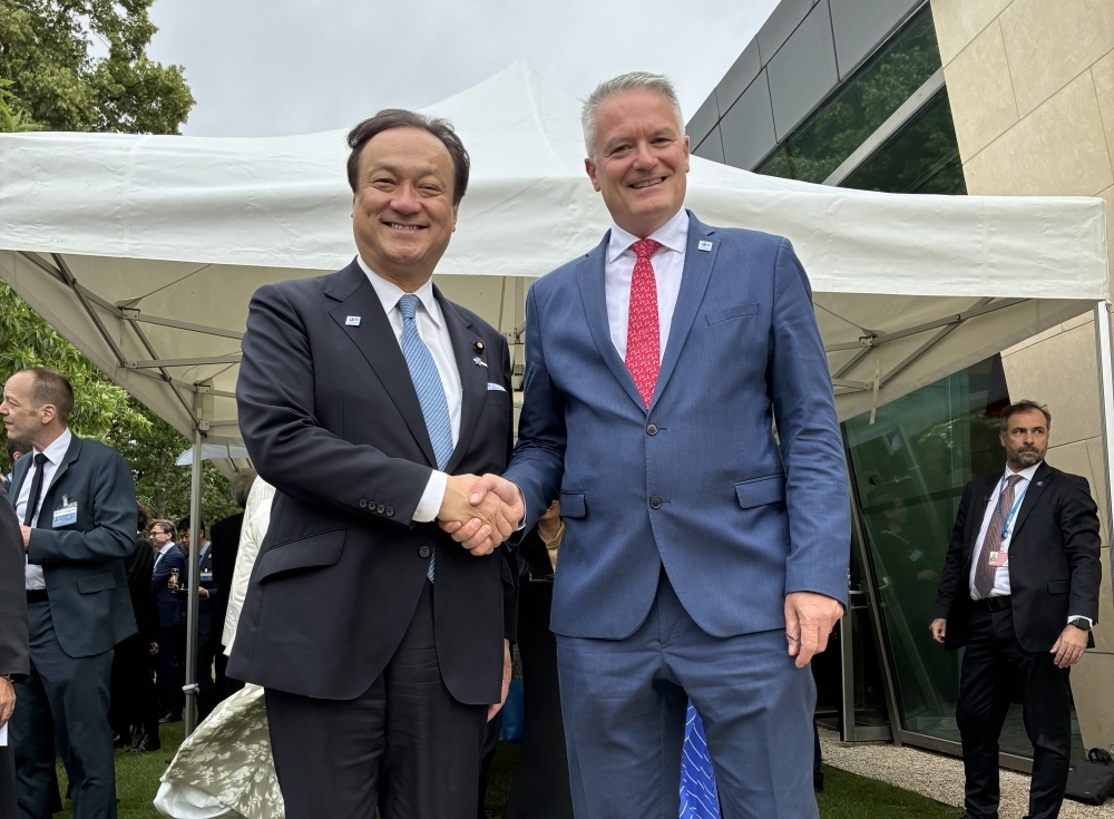 握手をする堀井外務副大臣とコーマンOECD事務総長