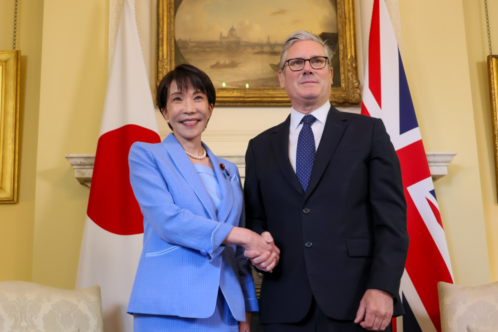 日英首脳会談少人数会合にて、両国旗の前で握手を交わす高市総理大臣とスターマー首相