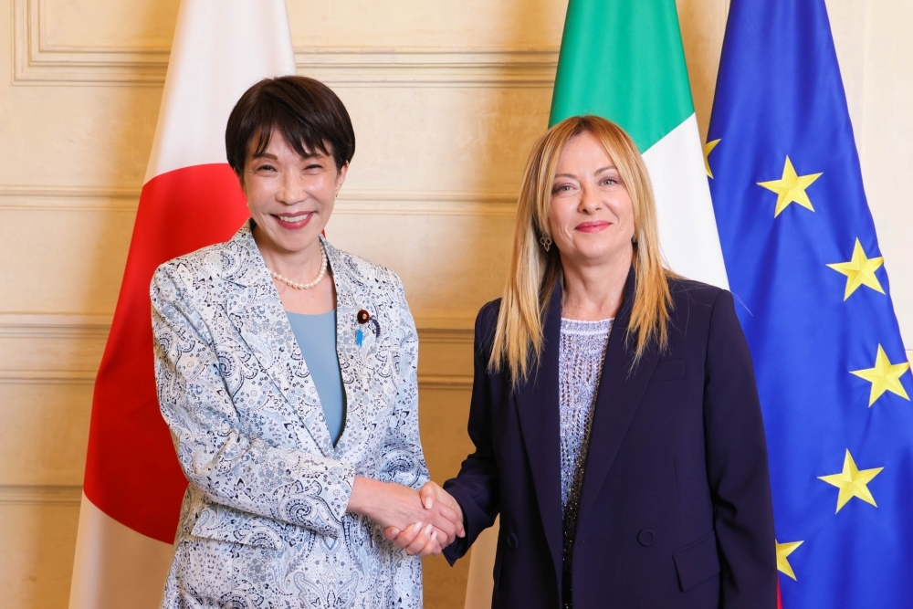 両国国旗の前で握手を交わす高市総理大臣とメローニ首相