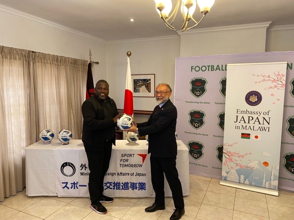 内藤康司駐マラウイ日本国大使からマラウイ・サッカー協会会長へボールが贈られる様子