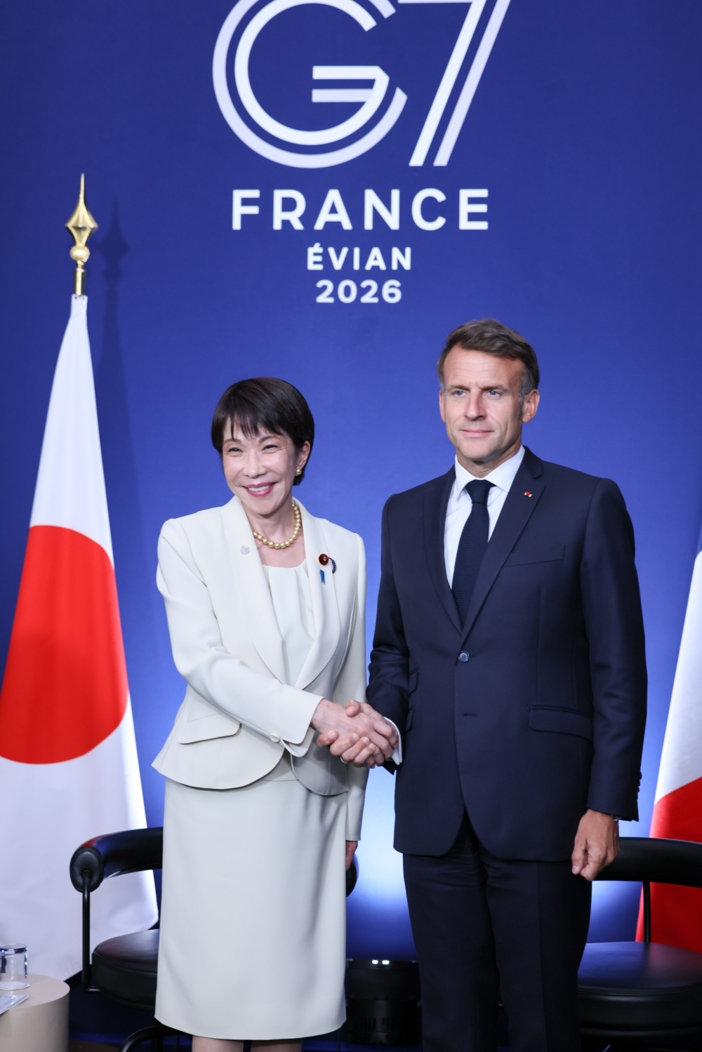 日仏首脳会談。高市総理大臣とマクロン仏大統領が、日本国旗とフランス国旗を背景に握手を交わしている。