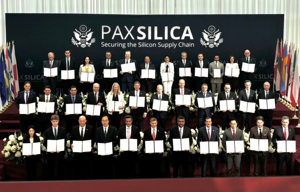 「パックス・シリカ・サミット」に参加した35か国・地域の代表者たちが、「PAX SILICA ― Securing the Silicon Supply Chain」と書かれた横断幕の前で、共同声明の署名文書を手に持ち、3列に並んで記念撮影をしている集合写真